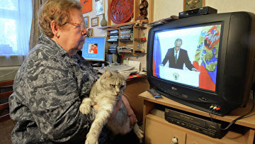 Жительница Челябинска смотрит телевизионную трансляцию послания президента РФ В.Путина к Федеральному Собранию