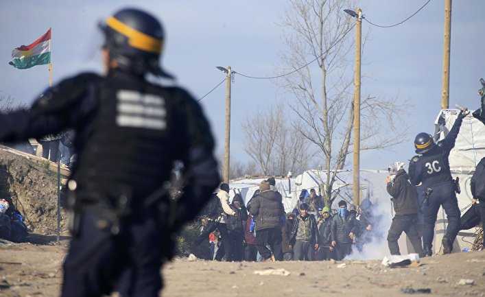 Сотрудники полиции во время беспорядков в лагере мигрантов "Джунгли" возле Кале, Франция