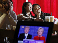 Люди смотрят трансляцию дебатов между Дональдом Трампом и Хиллари Клинтон