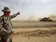 Солдат армии США дает знак экипажу танка М1А1 Abrams во время учений в Ираке