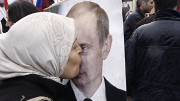 Сирийская женщина целует портрет президента РФ Владимира Путина