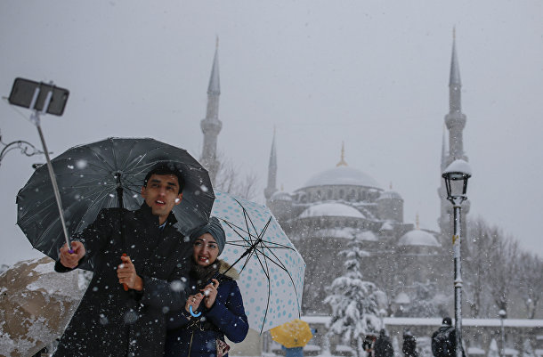 Парочка делает селфи на фоне заснеженного Собора Святой Софии в Стамбуле