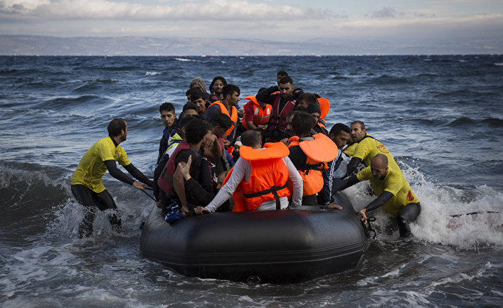 Спасатели помогают беженцам причалить у берега греческого острова Лесбос